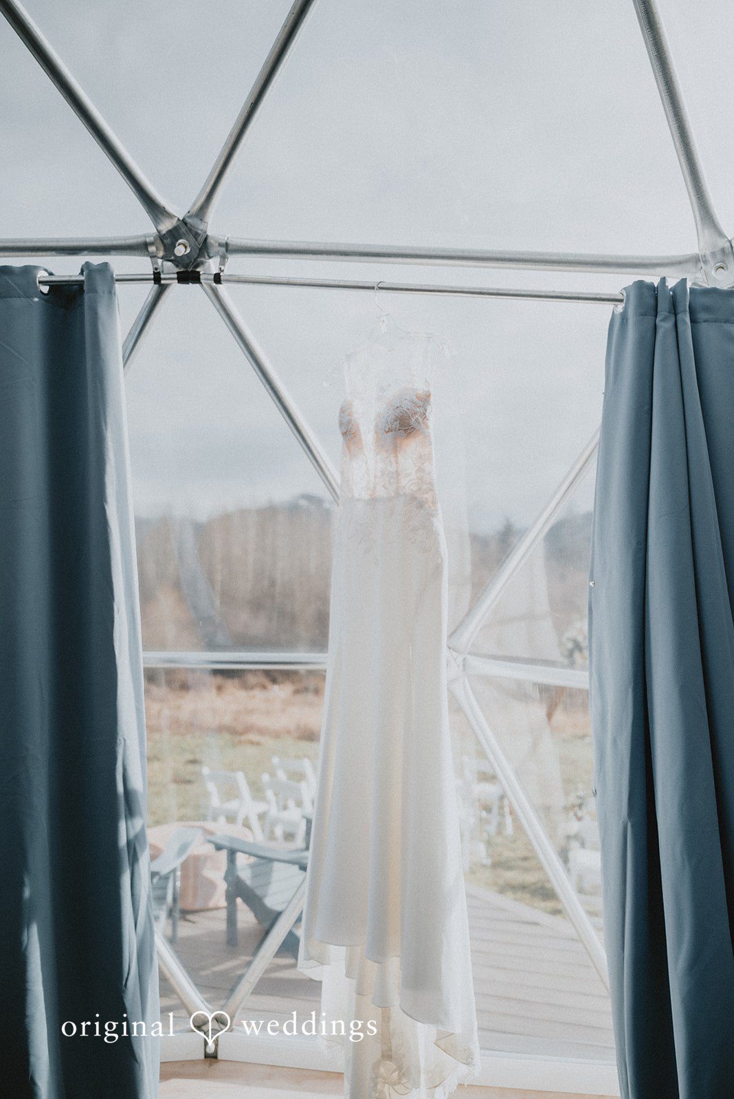 Kelsey + Adam Wedding dress hanging inside a light-filled room.