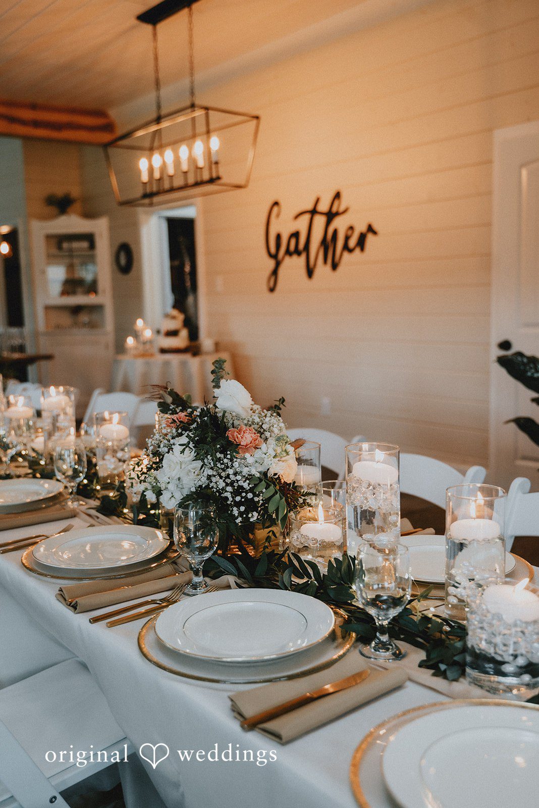 Kelsey + Adam Wedding reception table setup with plates and decor indoors.