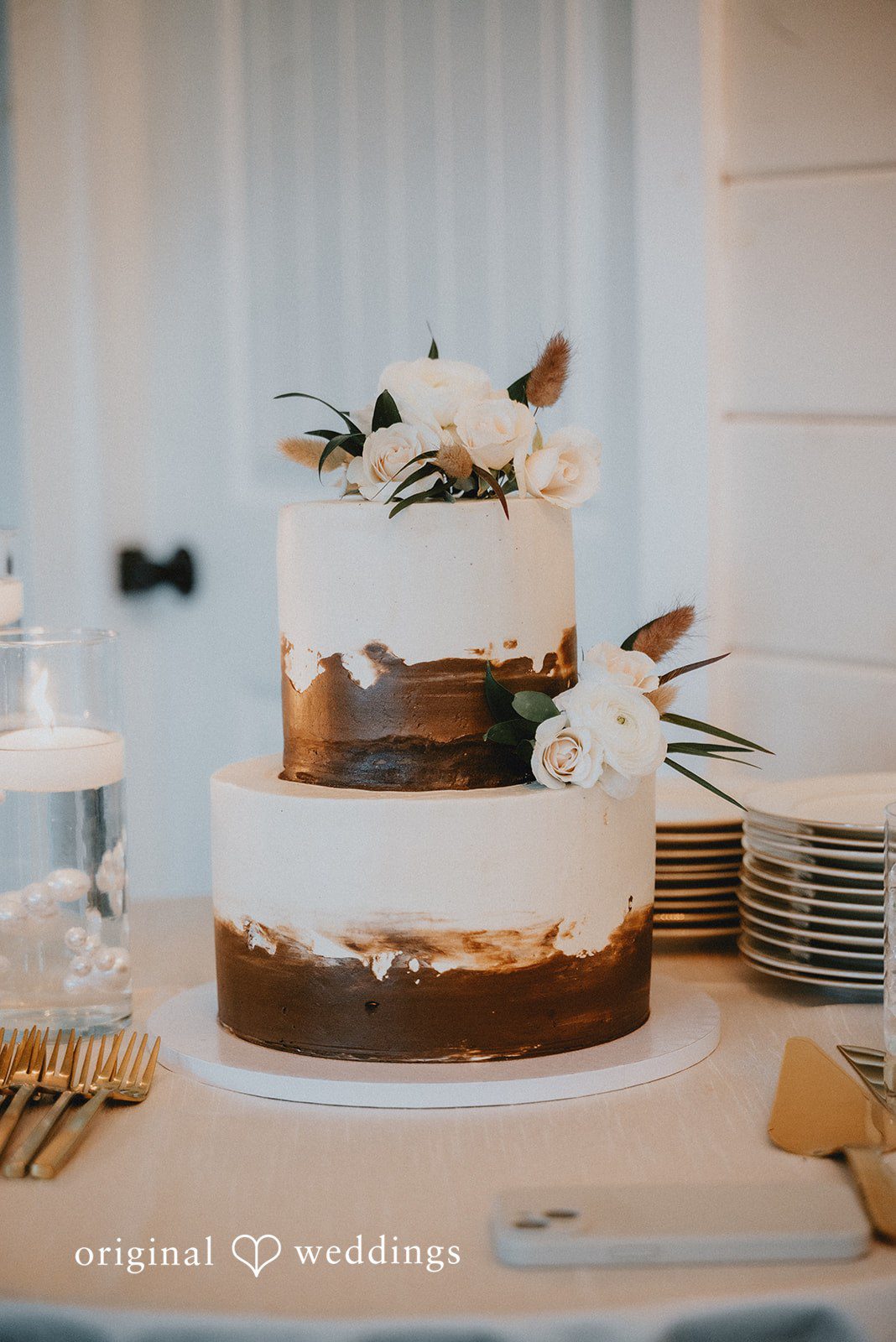 Kelsey + Adam Wedding cake with floral decorations on display table.
