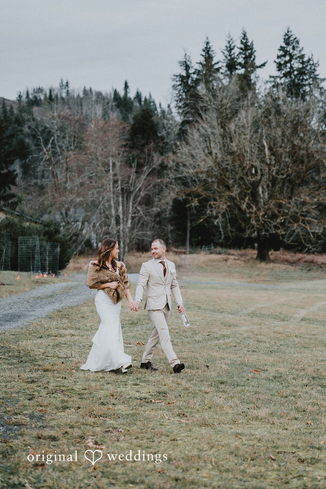 Kelsey + Adam Bride and groom walking in a field.