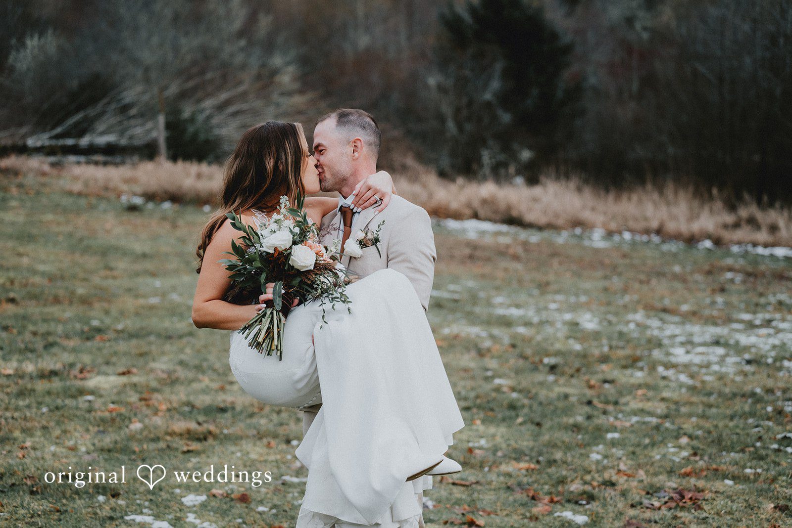 Kelsey + Adam Bride in white dress kissing groom outdoors, holding bouquet.