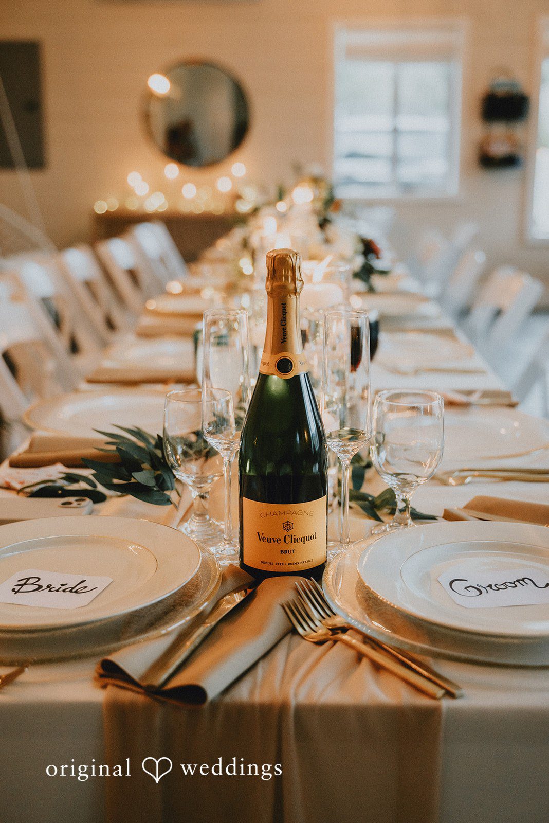 Kelsey + Adam Champagne bottle on elegantly set reception table.