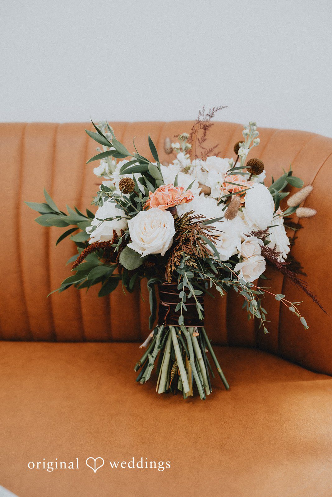 Kelsey + Adam Bridal bouquet with soft neutral flowers on wooden surface.
