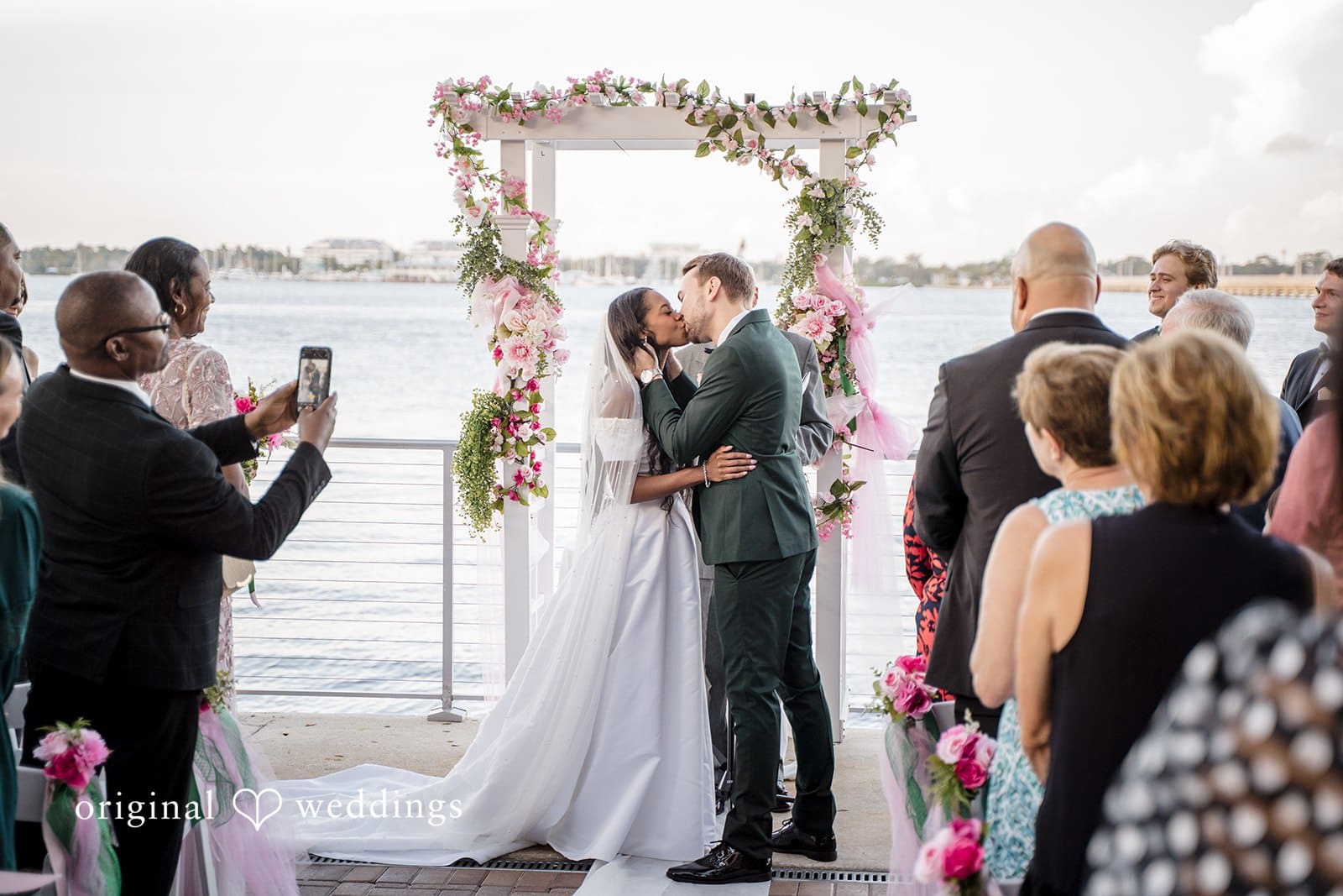 The couple walk happily through applause.