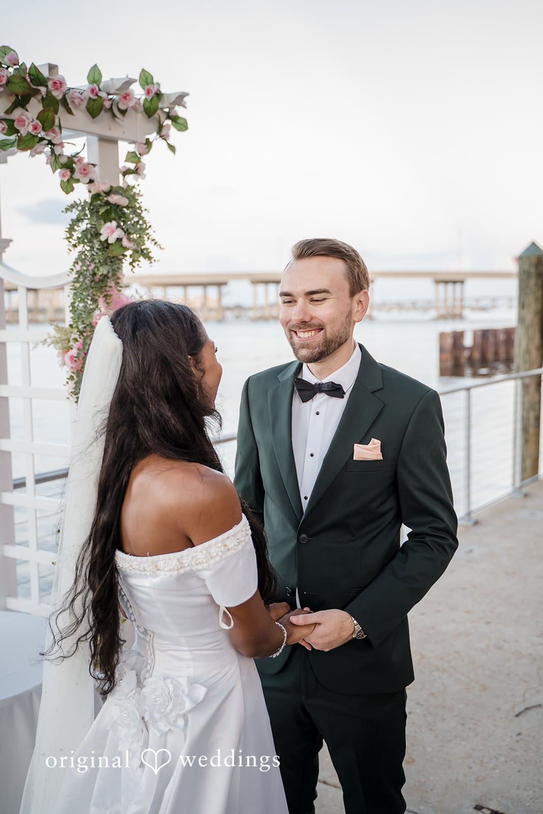 The bride and groom share a romantic moment by the seaside.