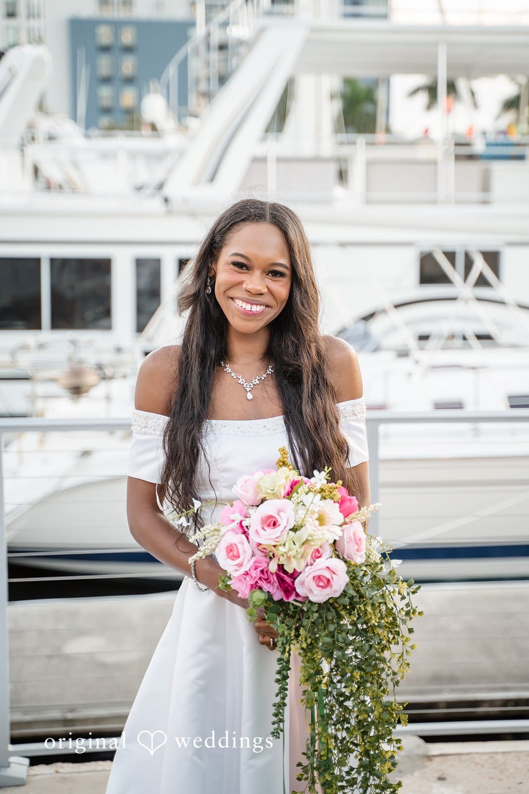 The bride poses gracefully holding her bouquet.