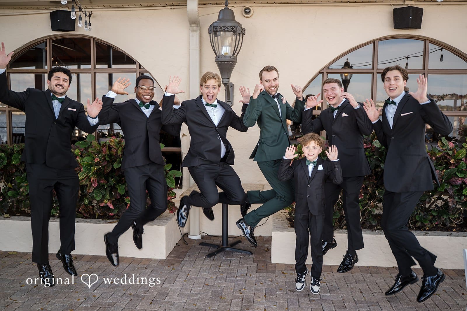 The groom and his friends jump joyfully for a fun photo.