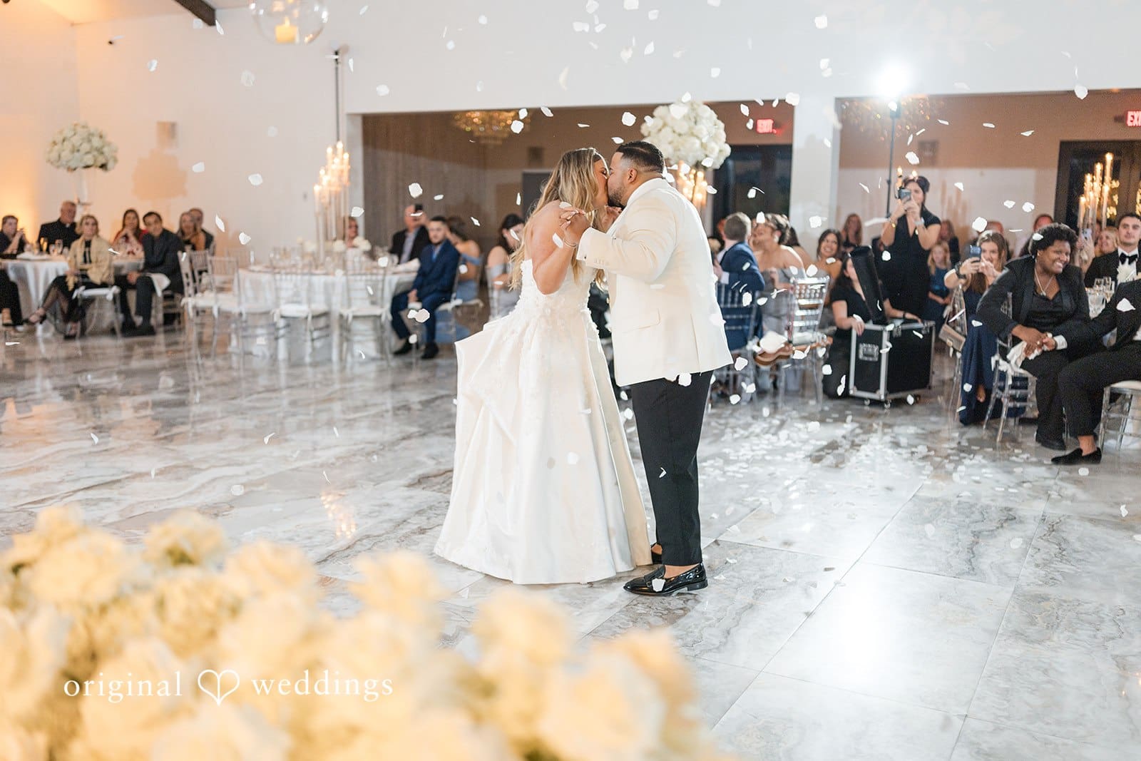 The couple shares a kiss at their wedding reception