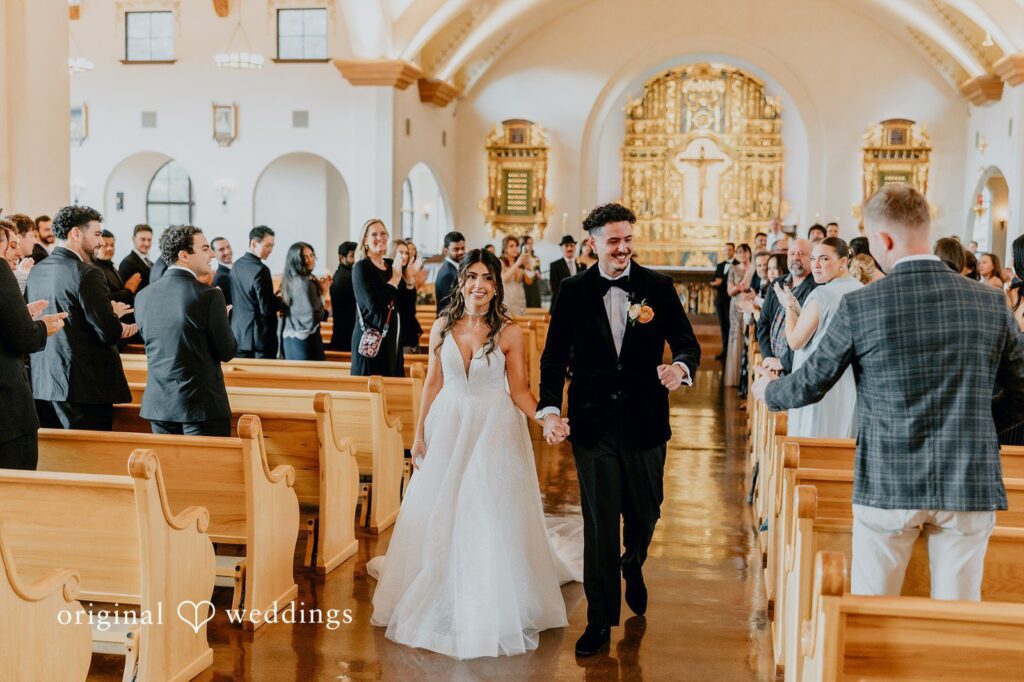 Jakob + Flowreen A beautiful San Diego wedding photography at Original Weddings showing the grand exit of the couple after their wedding ceremony at St Gabriel Catholic Church