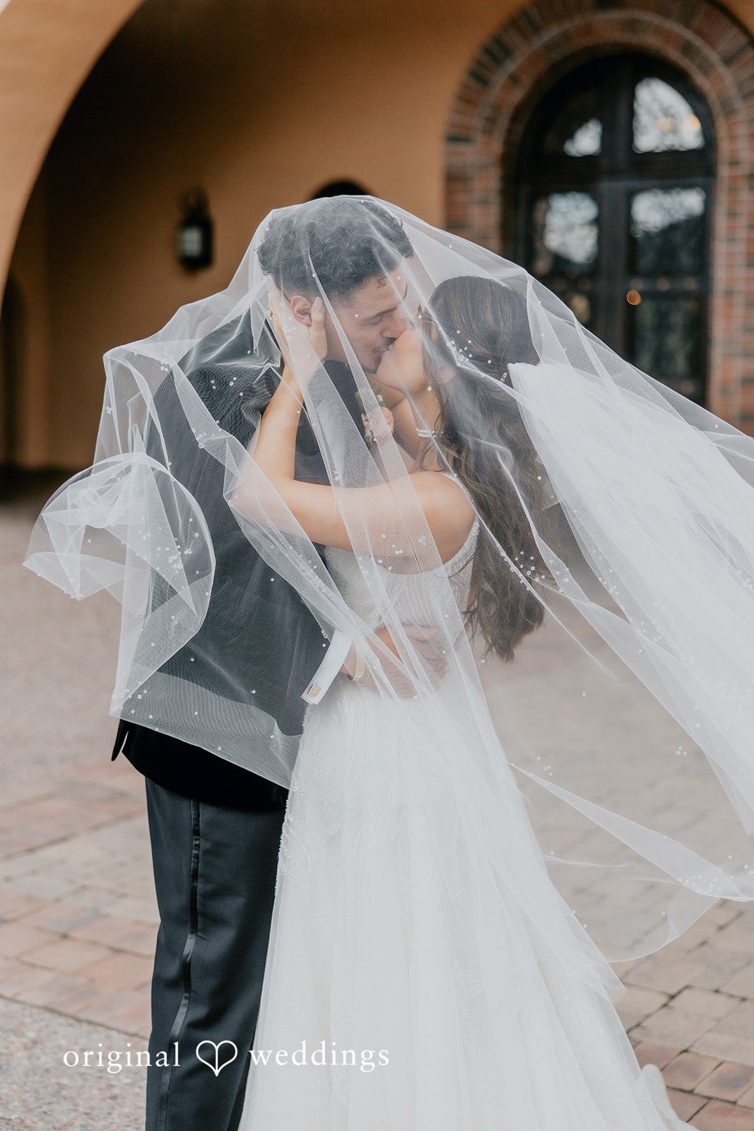 Jakob + Flowreen The couple shares a romantic kiss, masked in veil