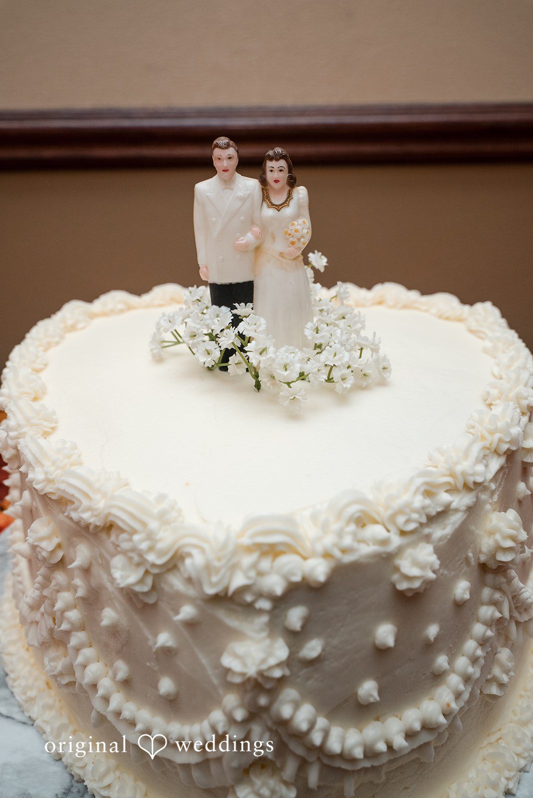 A detail shot of the all-white cake at the wedding reception