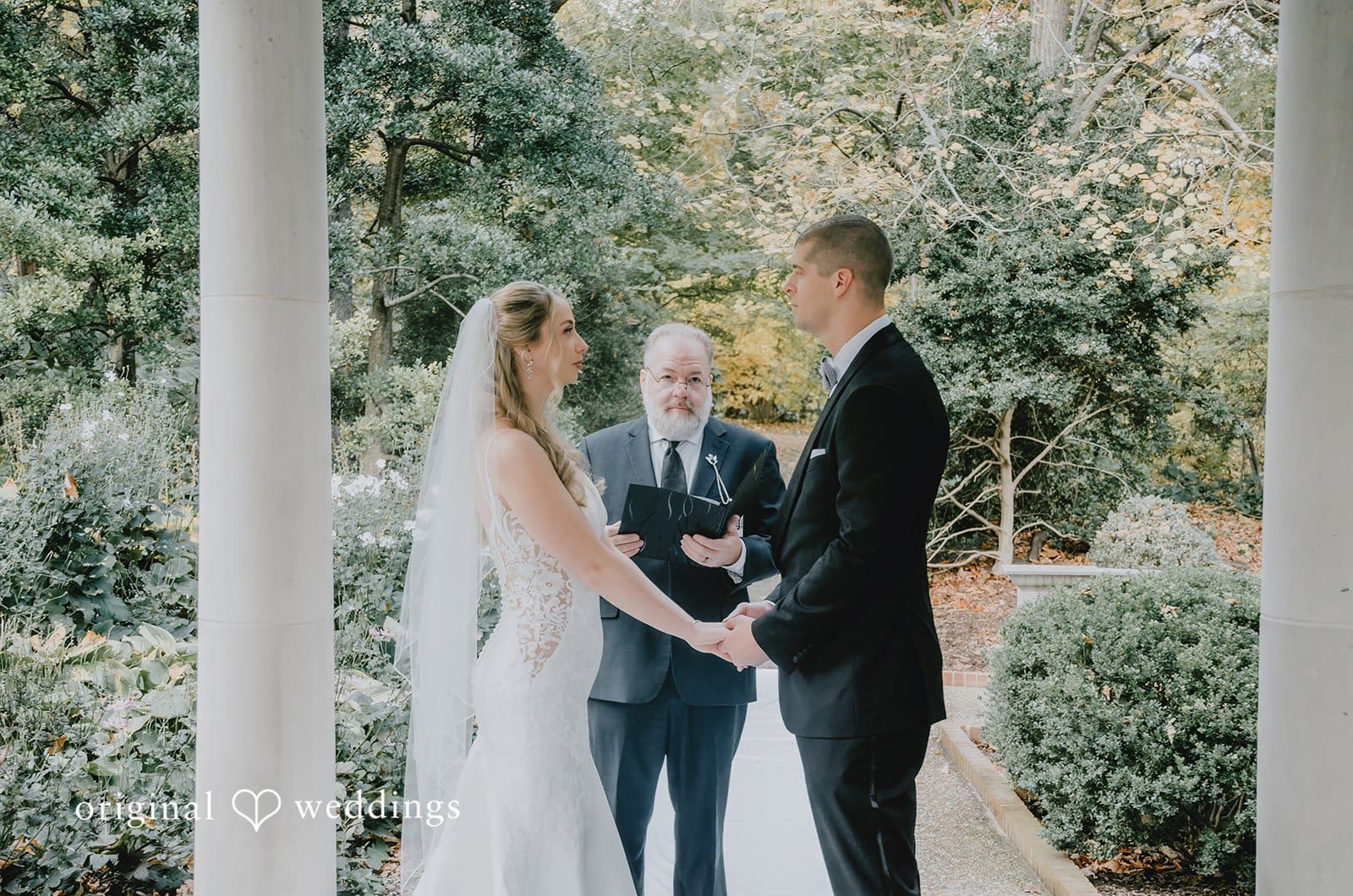 The bride and groom are exchanging marital vows at St. Louis Botanical Gardens