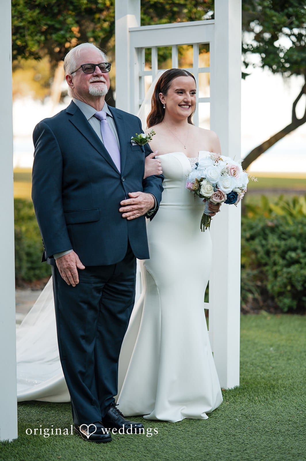 Bride walking down the garden aisle with her father during the outdoor wedding ceremony at Tampa Garden Club
