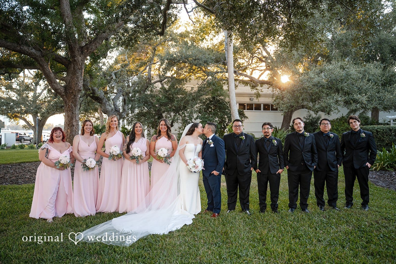 Wedding party with bridesmaids and groomsmen posing together outdoors