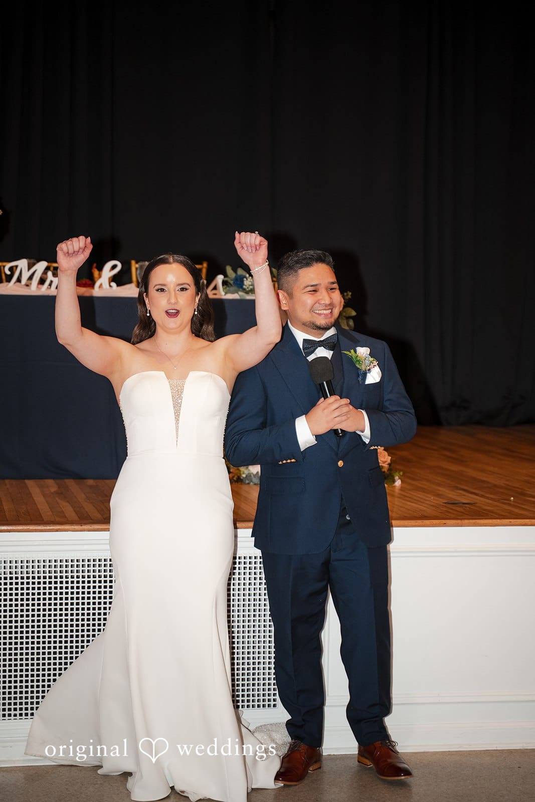 Groom giving a speech with a microphone beside the bride during the reception