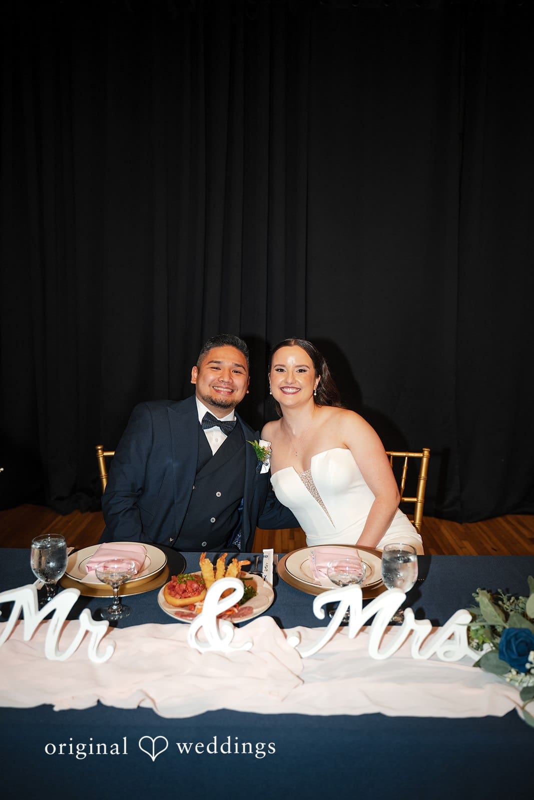 Bride and groom seated together at their sweetheart table during the reception