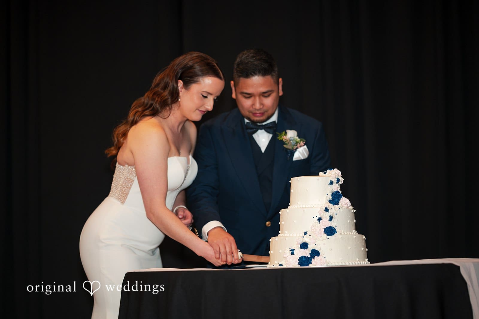Bride and groom cutting wedding cake at reception