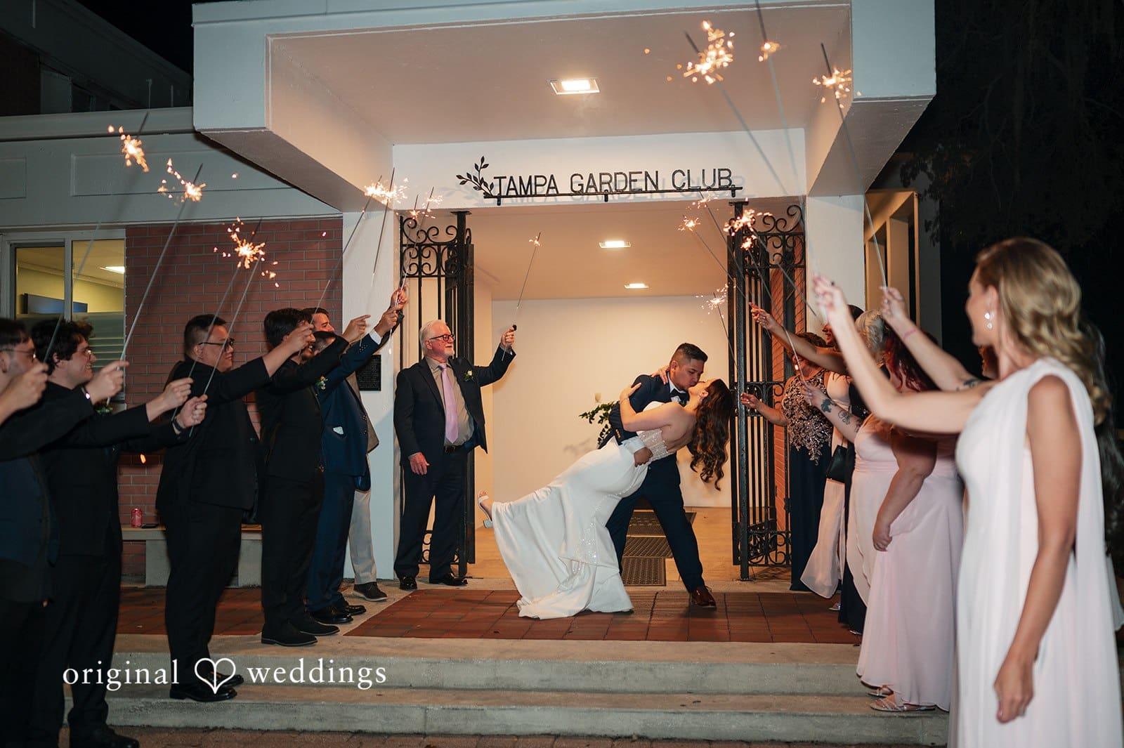 Bride and groom kissing during sparkler exit at Garden Club Tampa
