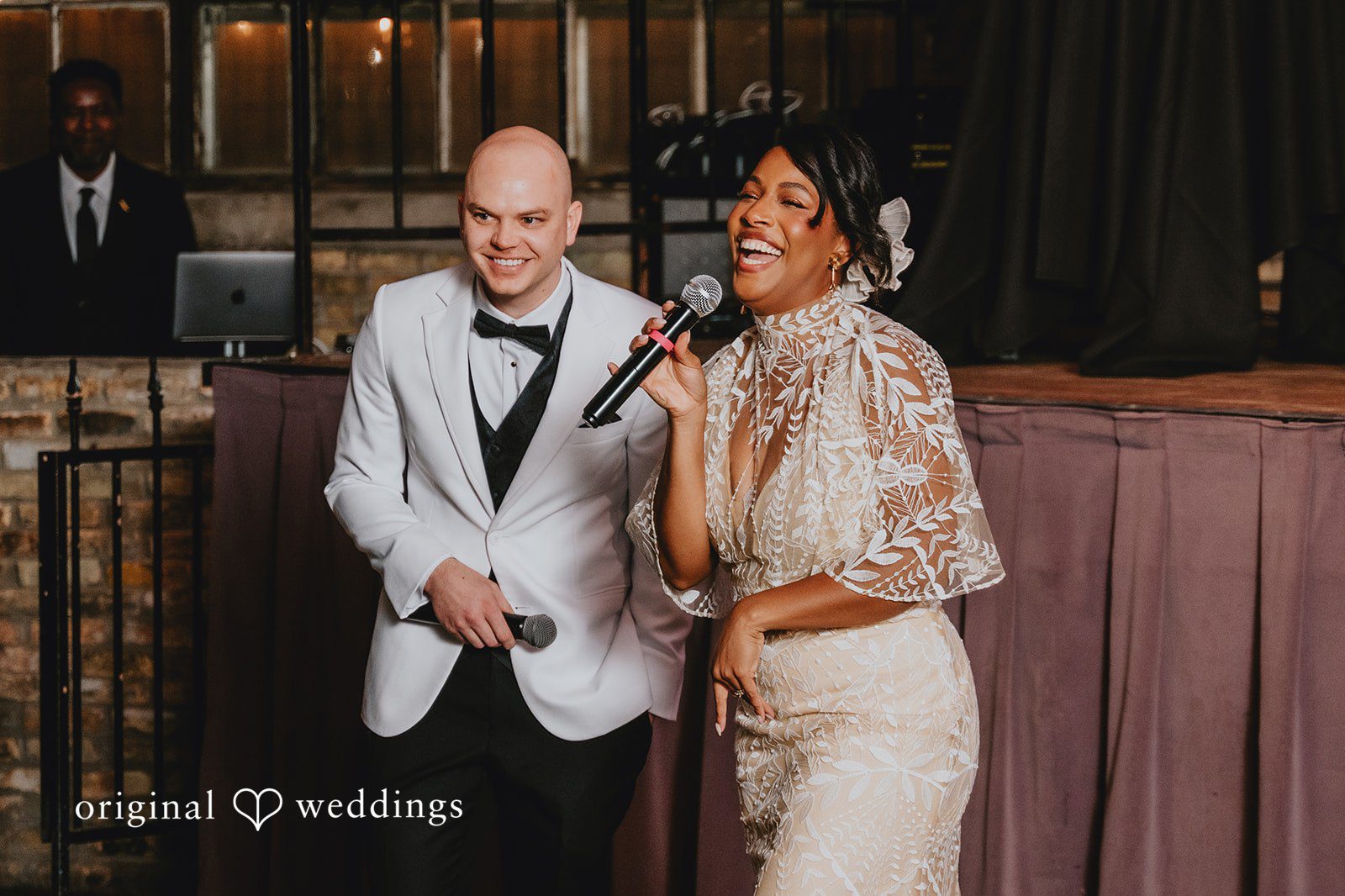 A joyful portrait of the couple addressing the guests at their wedding reception