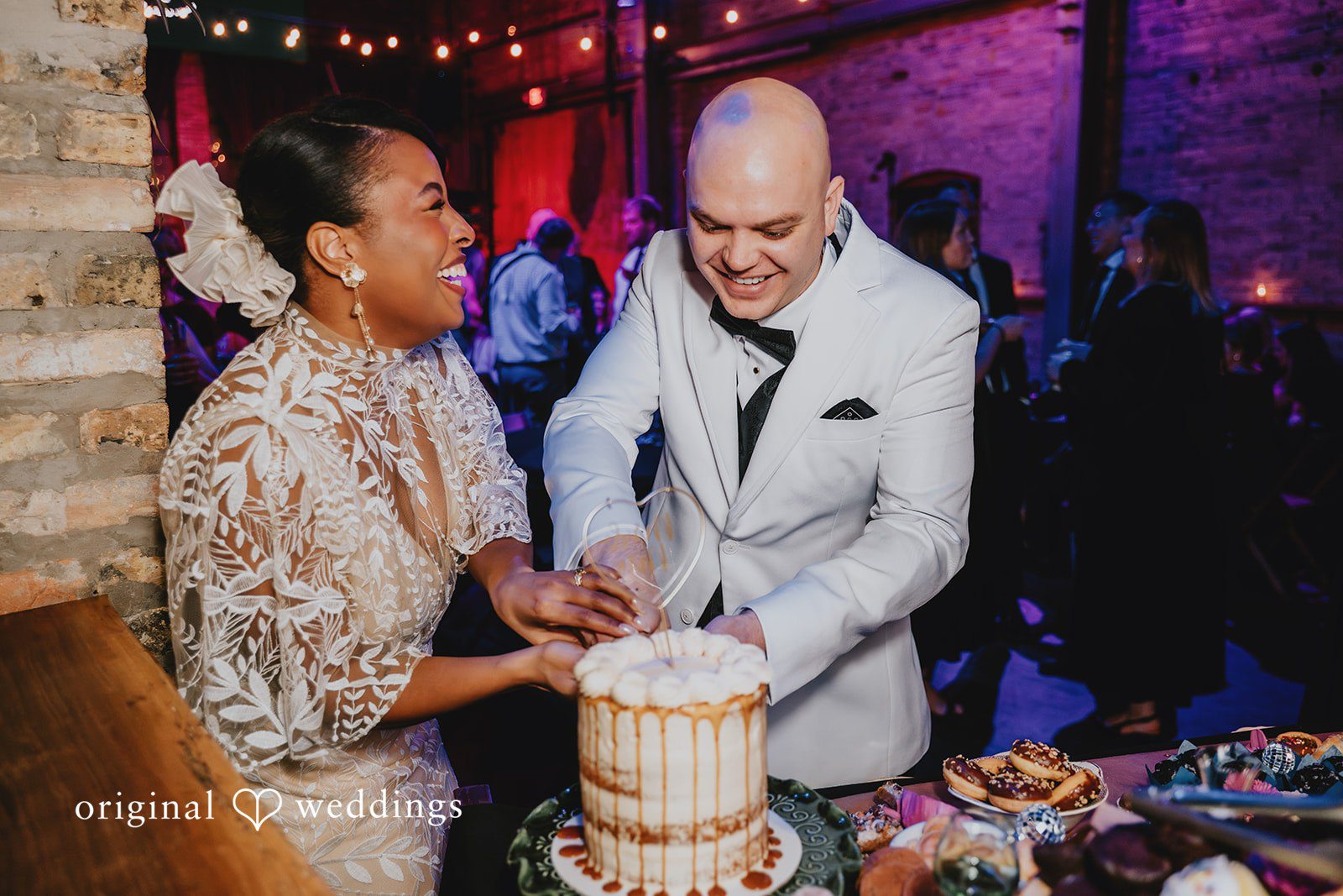 A happy couple cuts their wedding cake at The Cooperage
