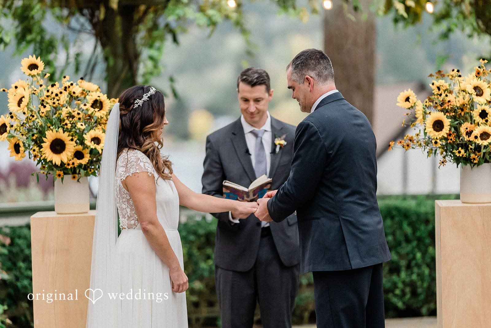 Bride and groom exchanging rings during outdoor wedding ceremony