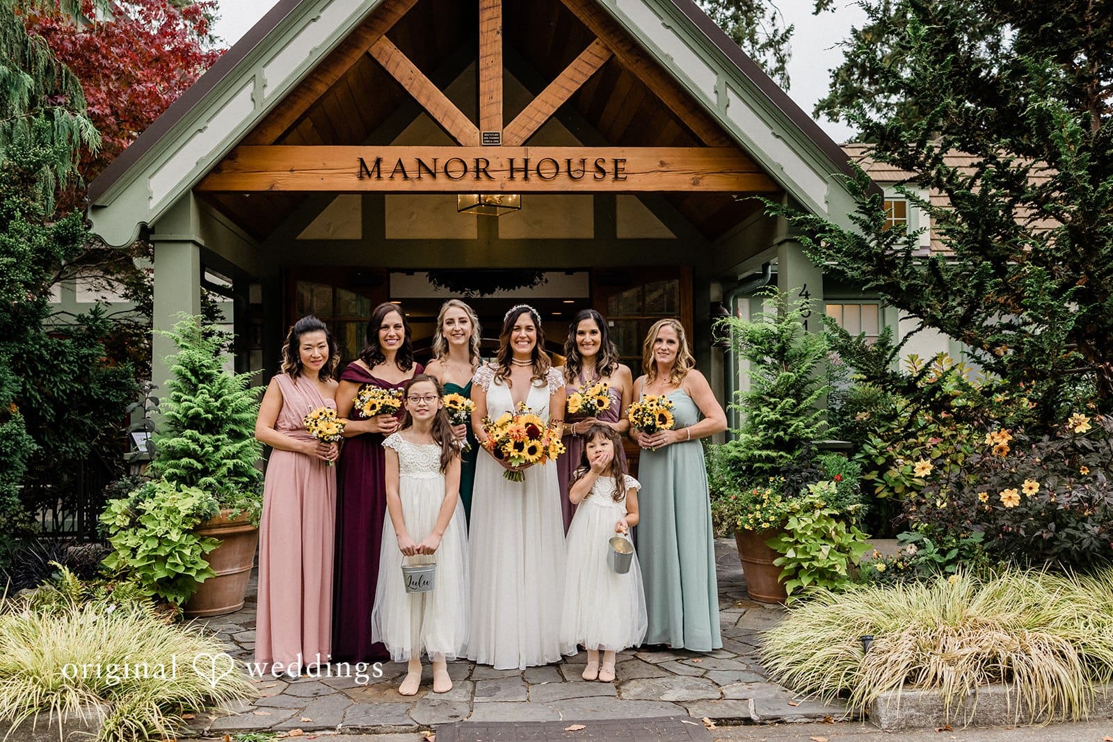 Bride standing with her bridesmaids in formal dresses, smiling together