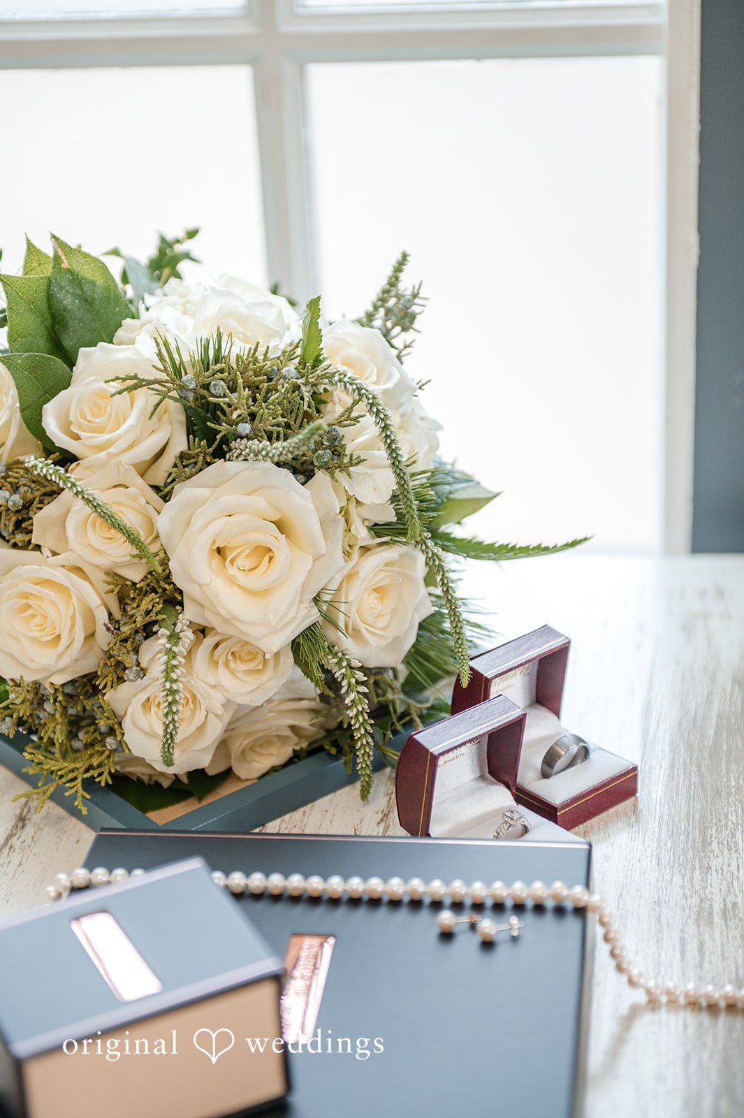 Caitlyn + Greg Bridal bouquet with white roses on a table at The Osprey’s at Belmont Bay