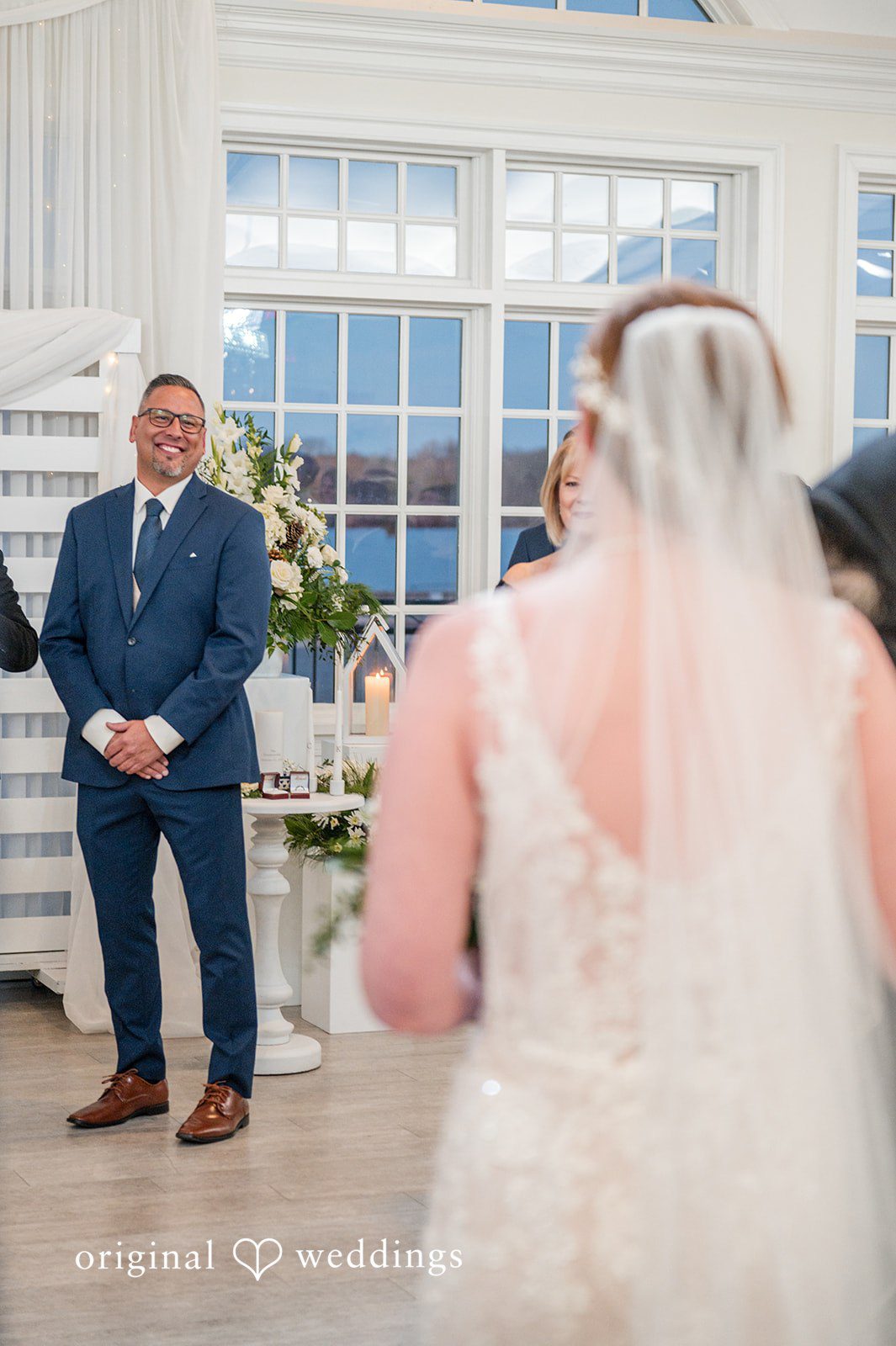 Caitlyn + Greg Groom smiling during ceremony as bride approaches.