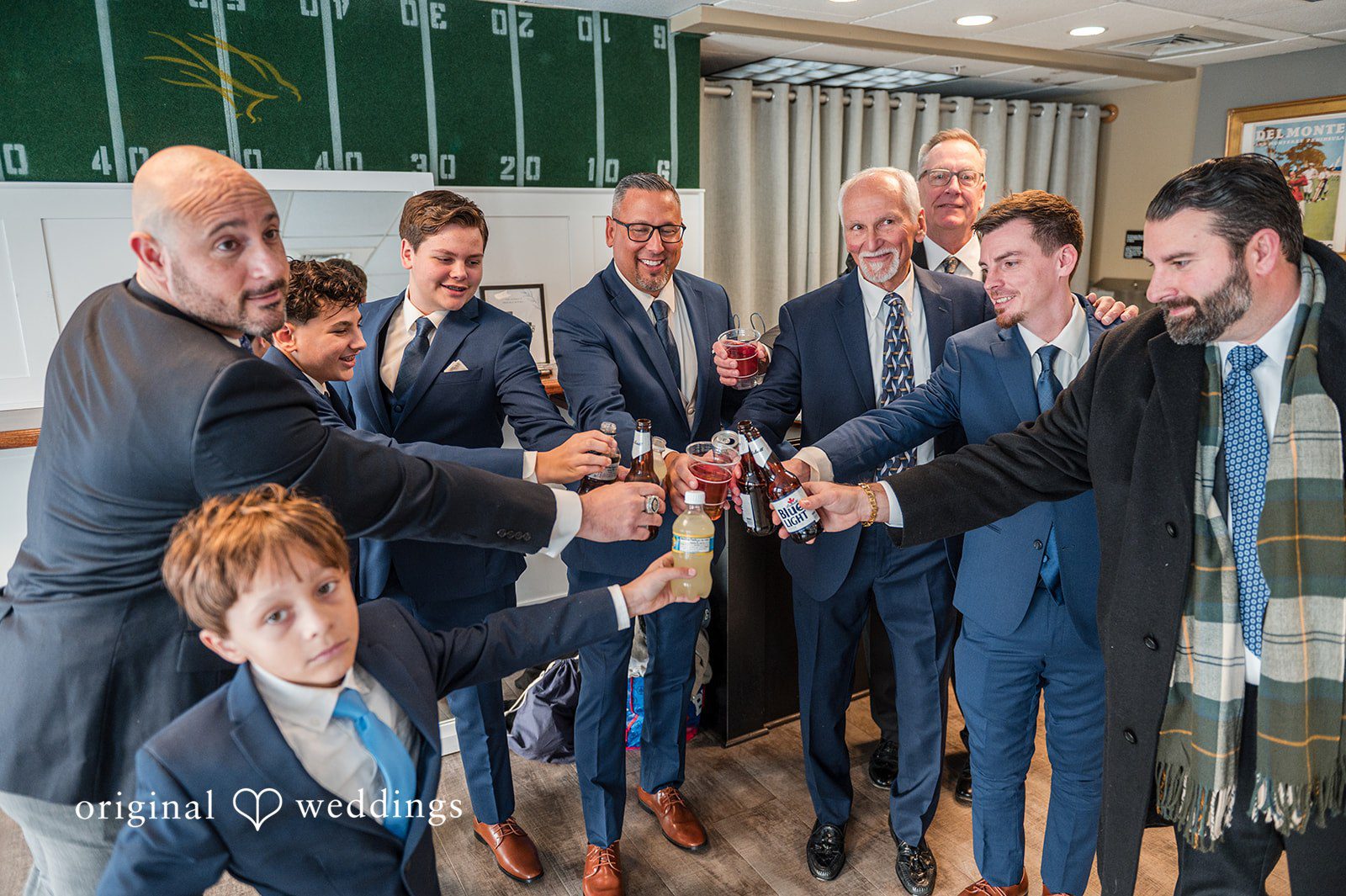 Caitlyn + Greg Groomsmen cheering together in suits during celebration