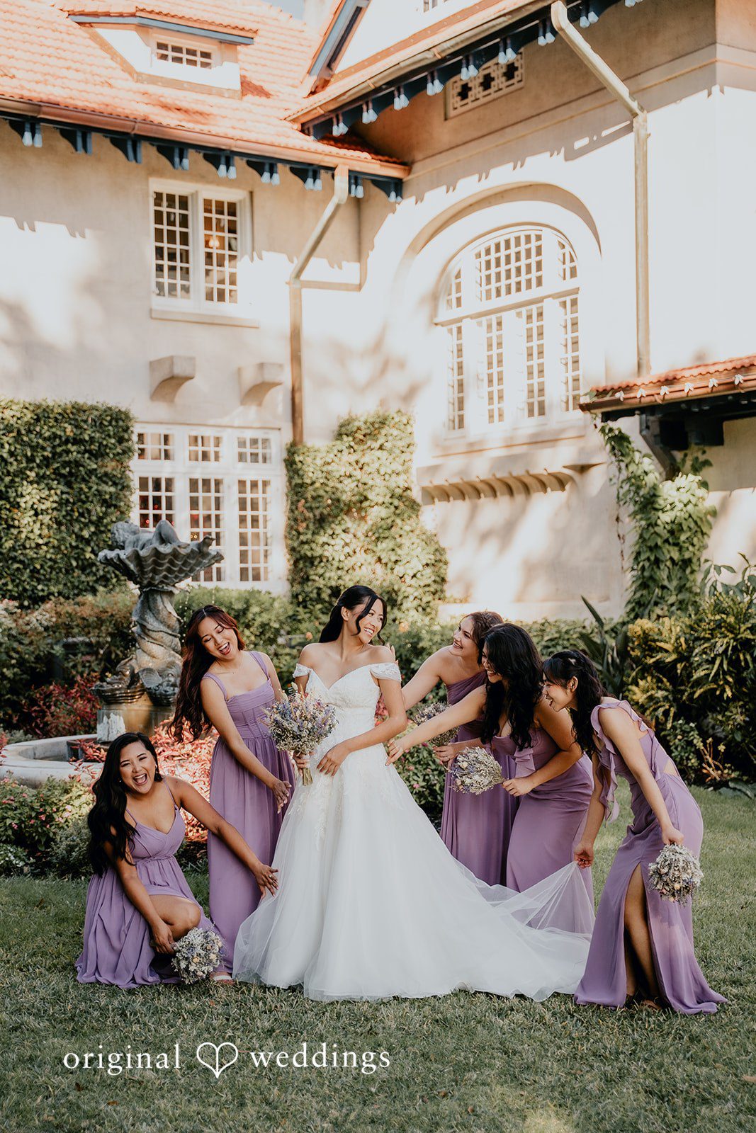 Bridesmaids gather around the bride in a joyful moment.