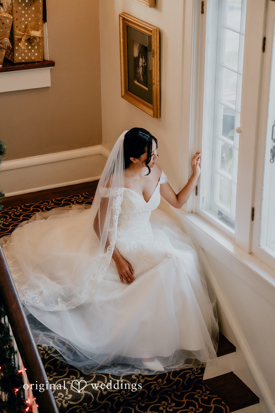 Trisha + Jacob The bride sits by the window in a soft, romantic light.
