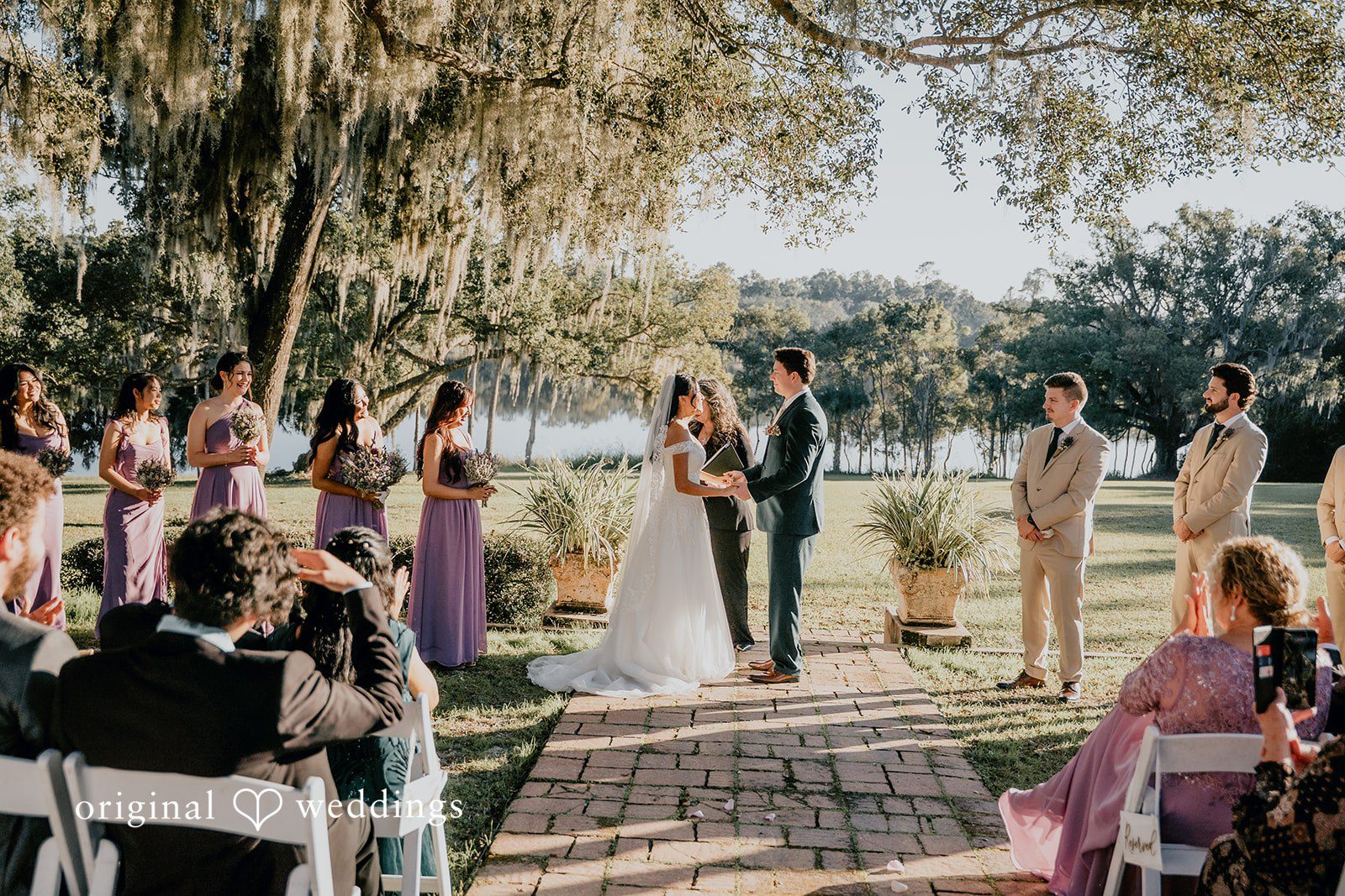 A romantic outdoor ceremony captured with Orlando wedding photography, as the bride and groom exchange vows surrounded by nature and loved ones.