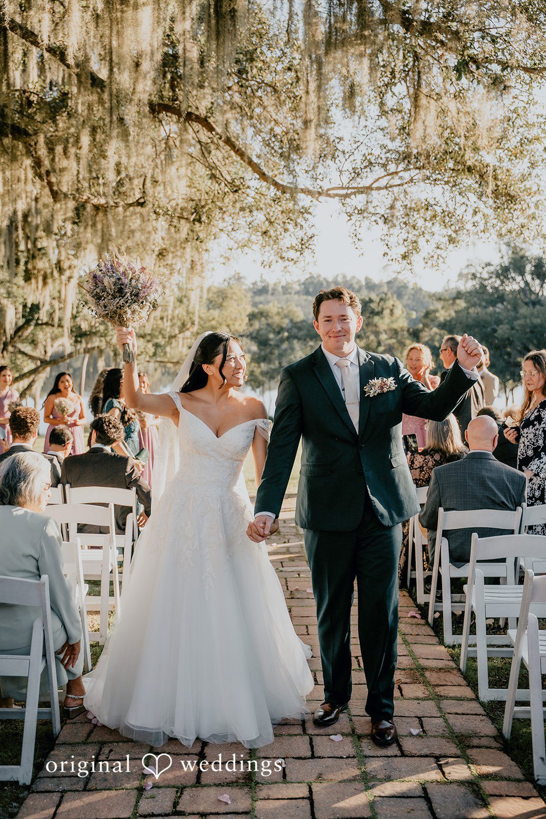 The couple celebrates under a joyful arch of friends.