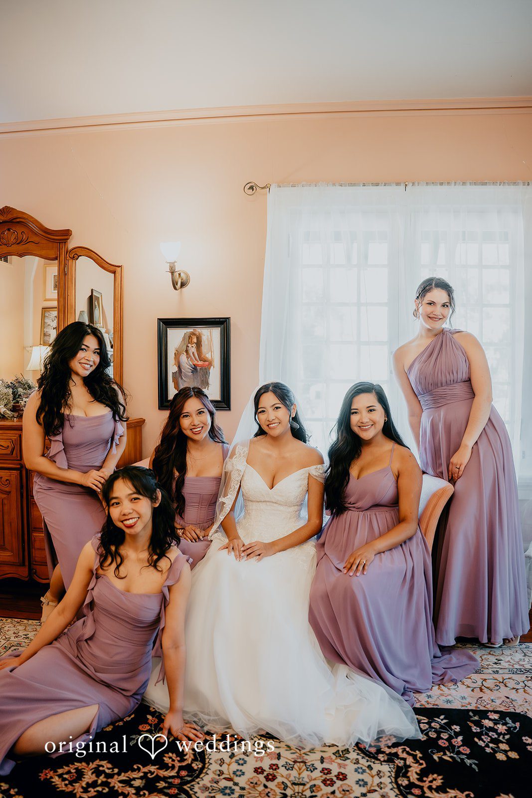 Trisha + Jacob The bride shares a joyful moment with her bridesmaids indoors.