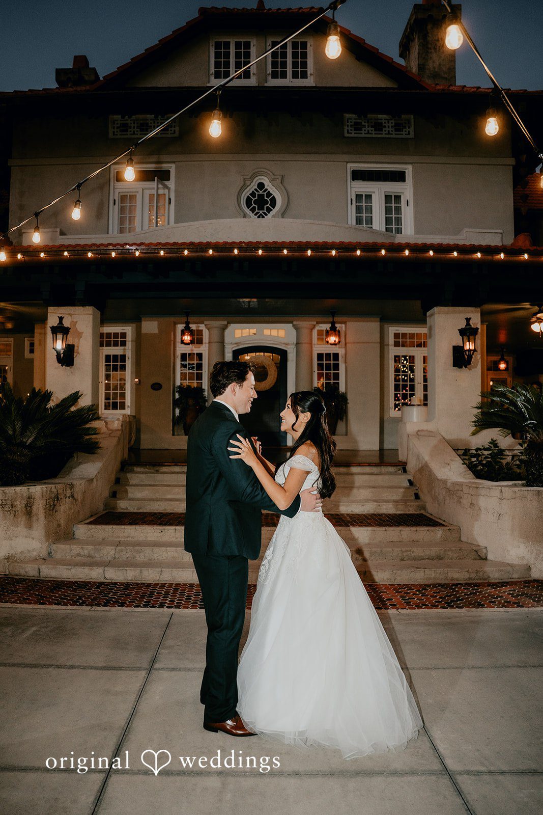 The couple shares their first dance under soft evening lights.