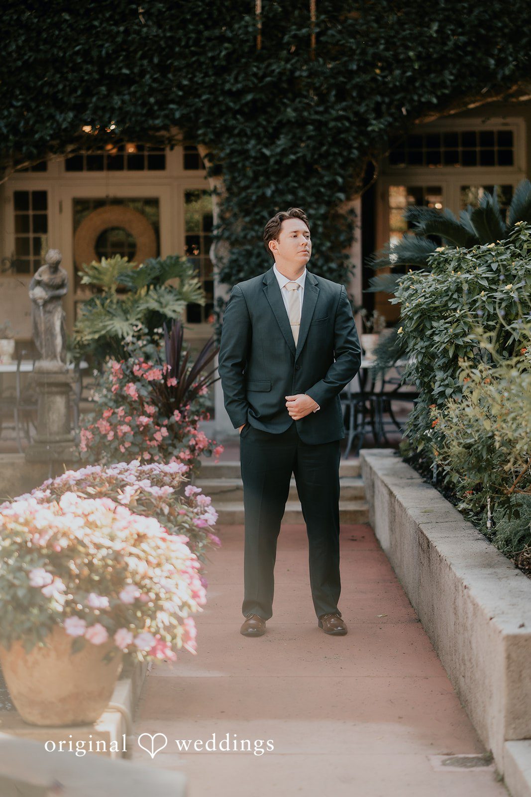 The groom stands confidently in a serene outdoor setting.