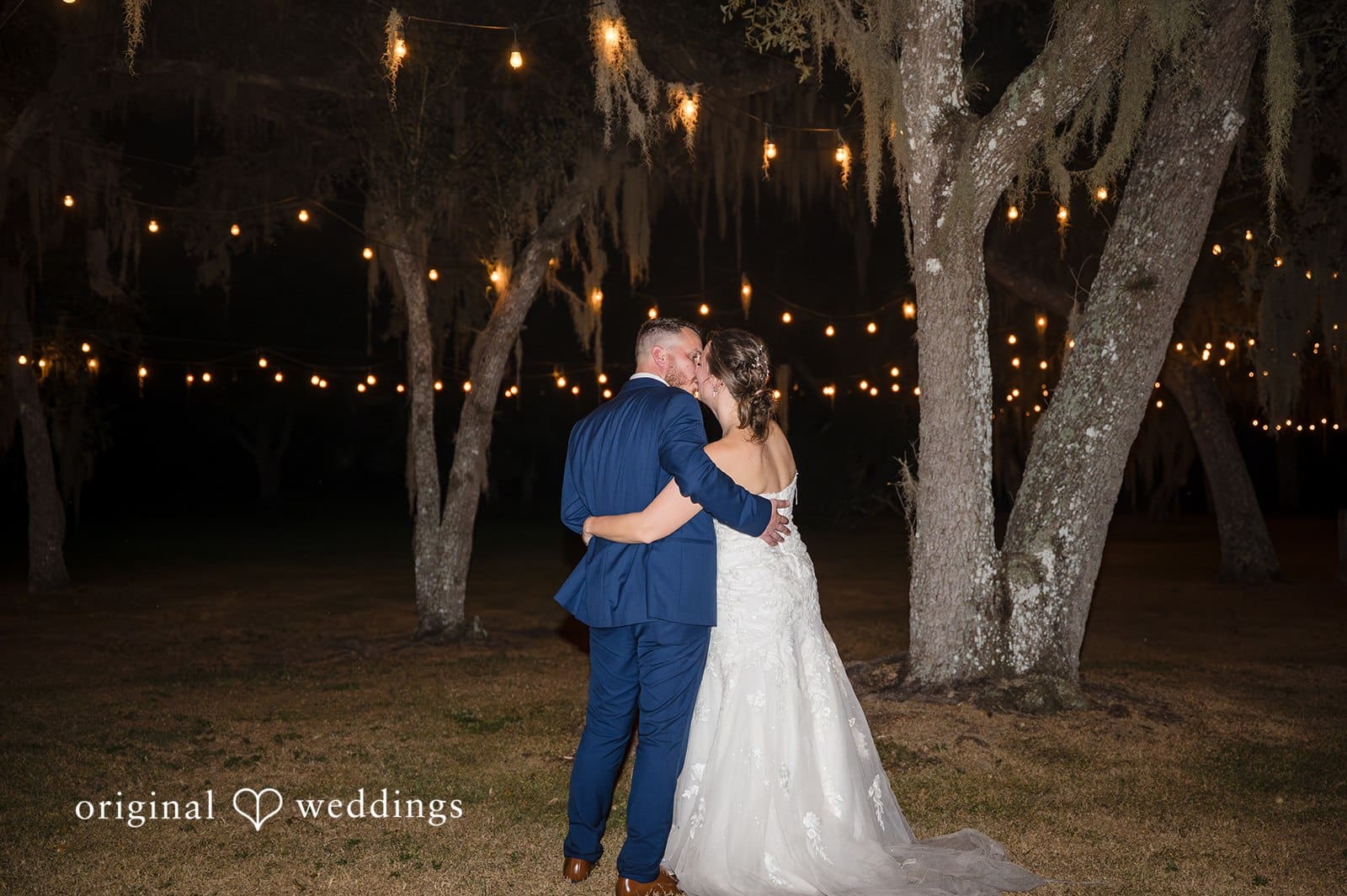 The couple shares a romantic moment under the evening lights.