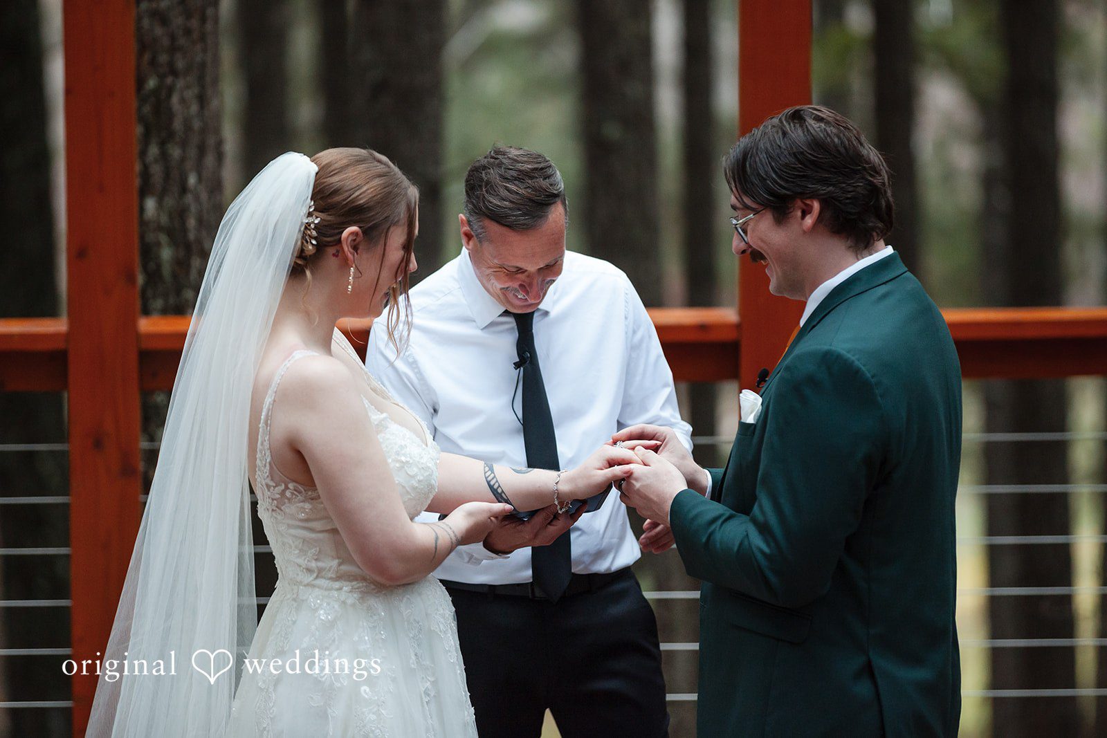 The groom puts a ring on bride's finger