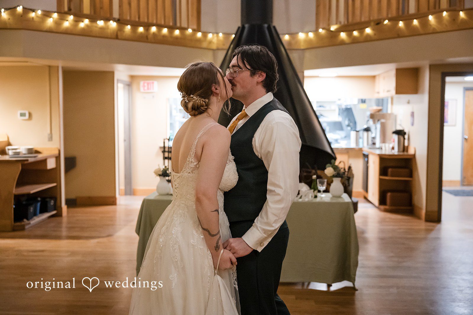 The couple shares a kiss at their wedding reception
