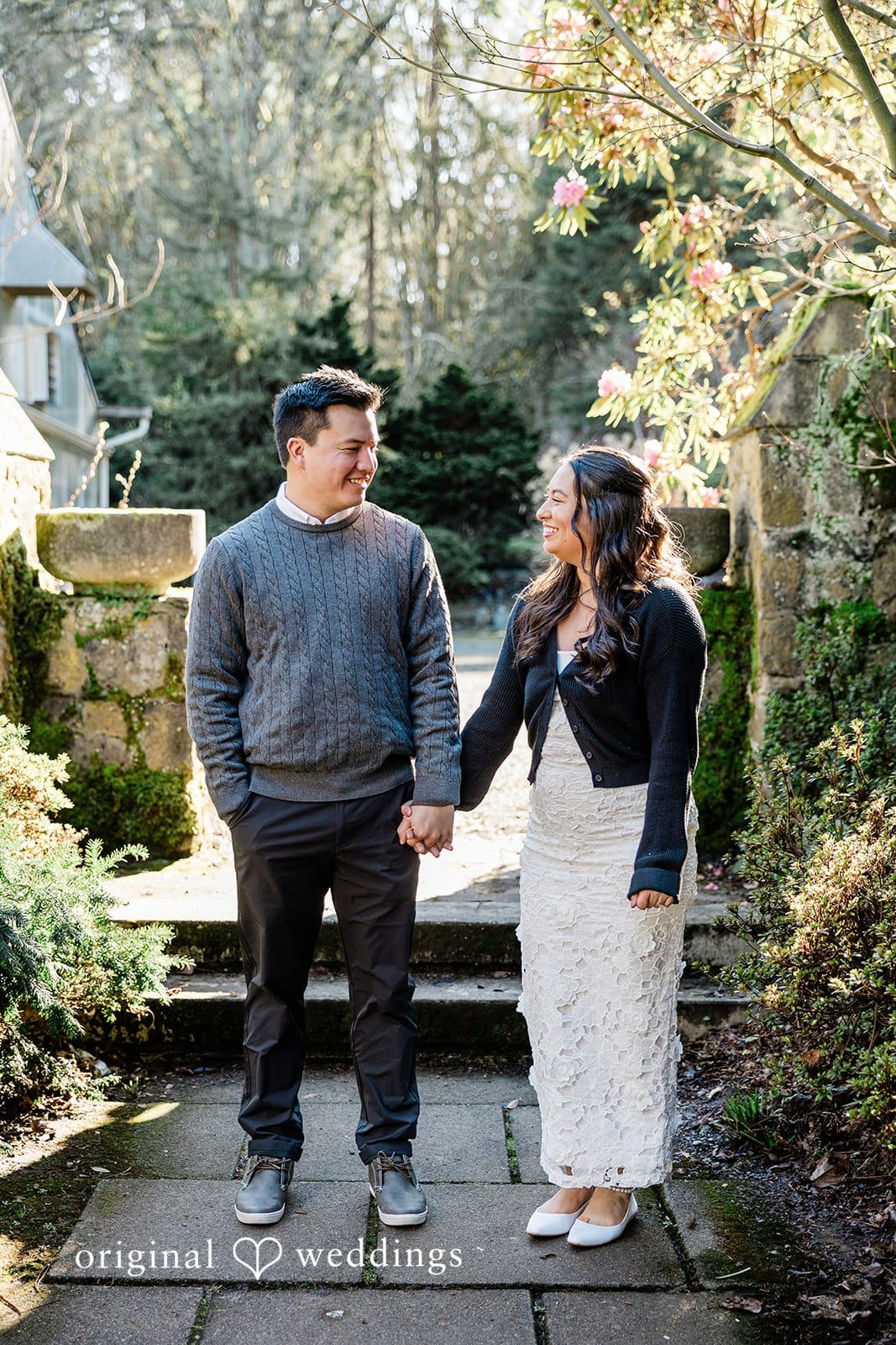 Sweet engagement portrait of couple holding hands and smiling at each other at Washington Park Arboretum