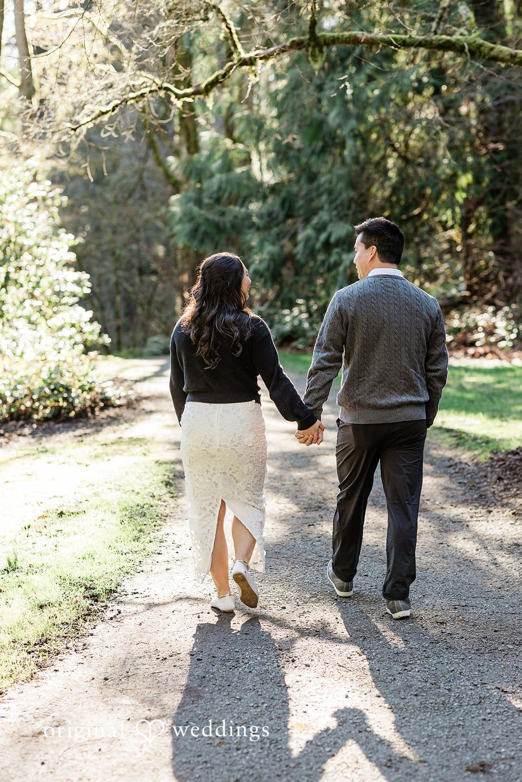 Close-up of couple’s backs as they walk together at Washington Park Arboretum