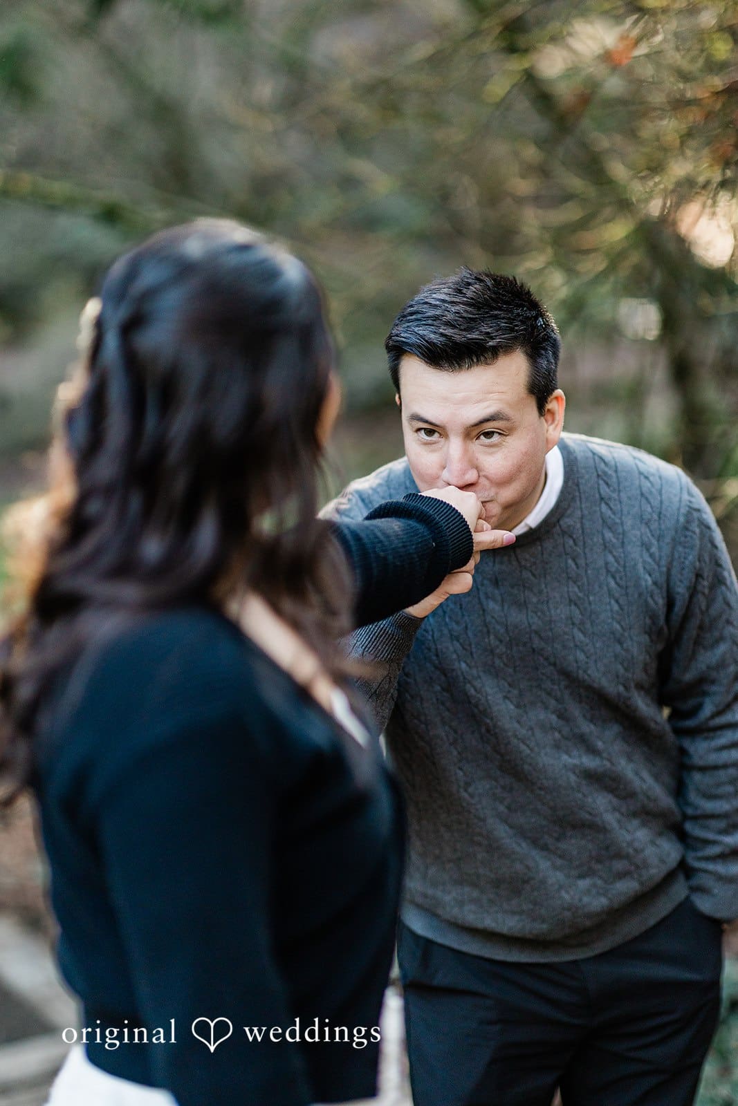 Close-up of bride’s hand being kissed by groom during engagement session at Washington Park Arboretum