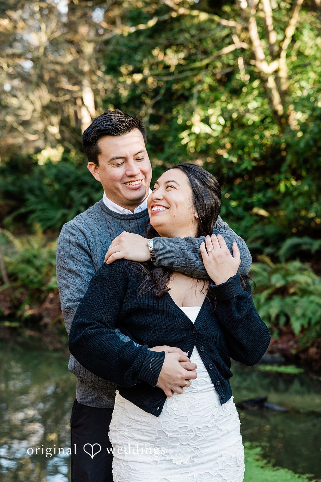Original Weddings capturing affectionate back hug of couple with joyful expressions at Washington Park Arboretum
