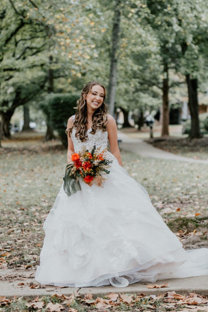 Drew + Bailee bride in lush greenery holding bouquet captured by st louis wedding photographer