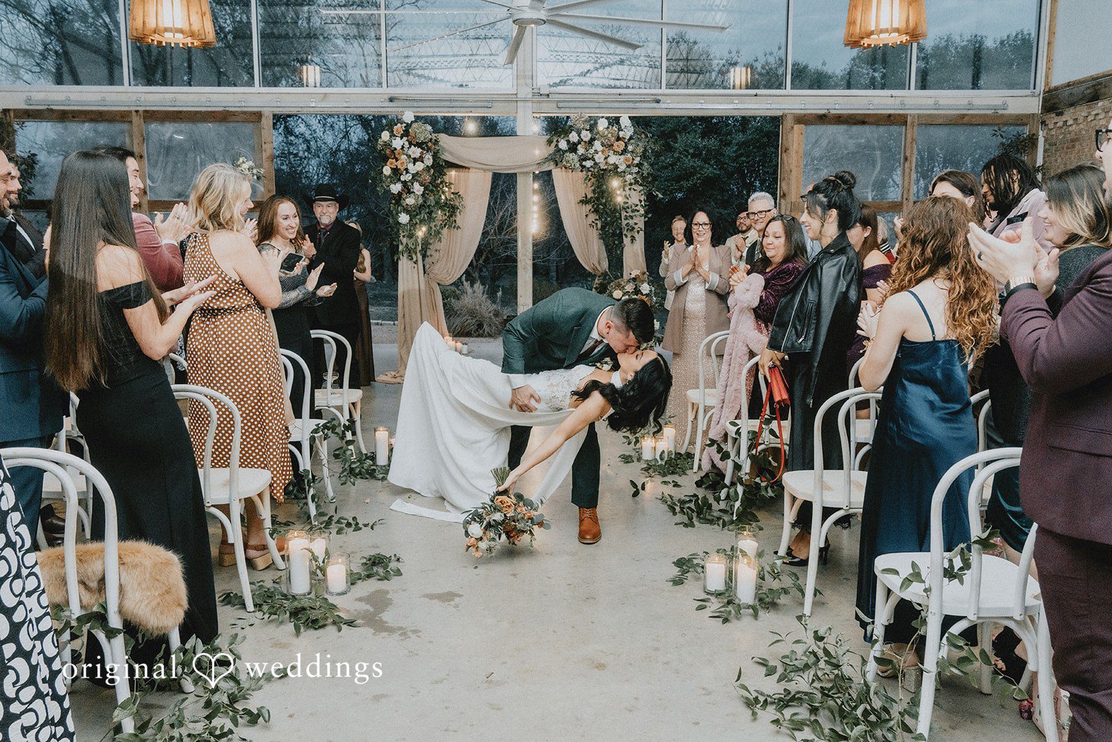 The couple seals their ceremony exit with a romantic kiss