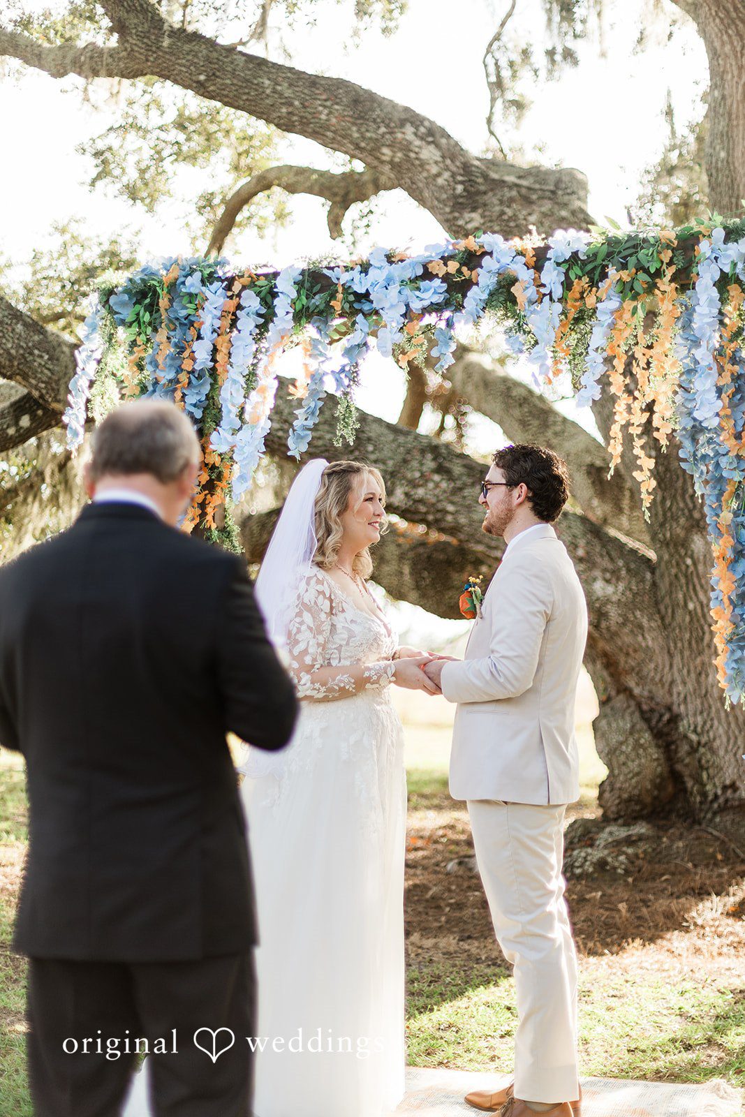 An intimate ceremony moment under hanging florals, documented through Tampa Wedding Photography.