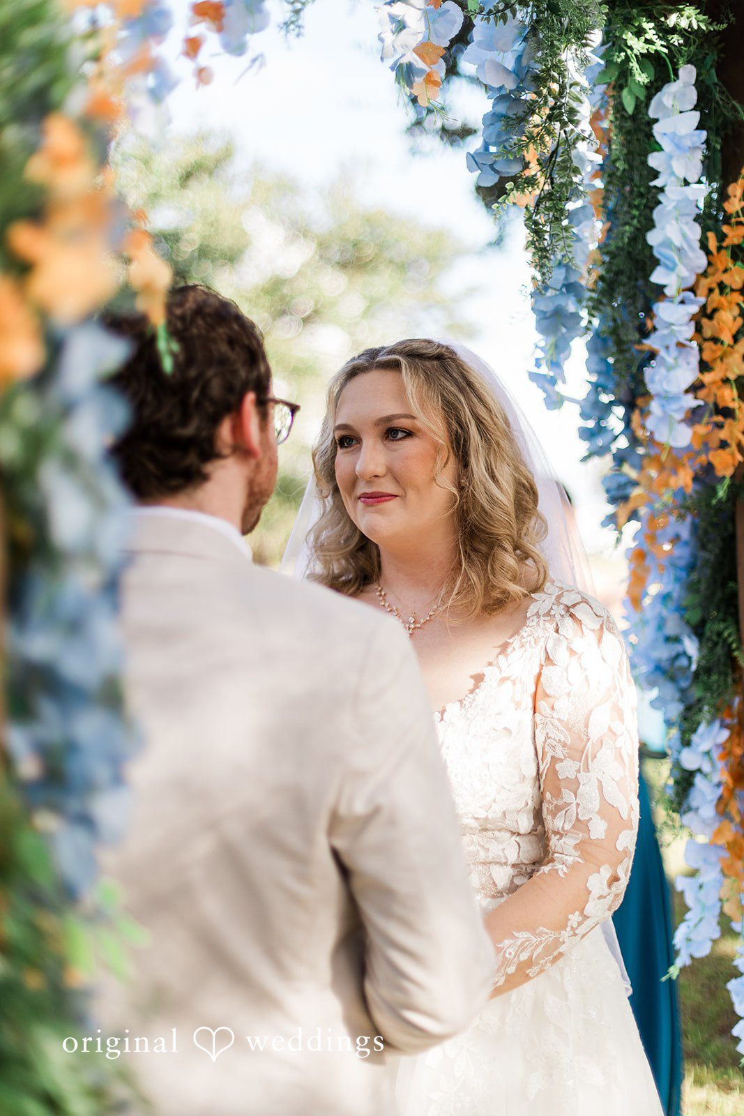 A close ceremony exchange beneath florals, photographed with Tampa Wedding Photography.