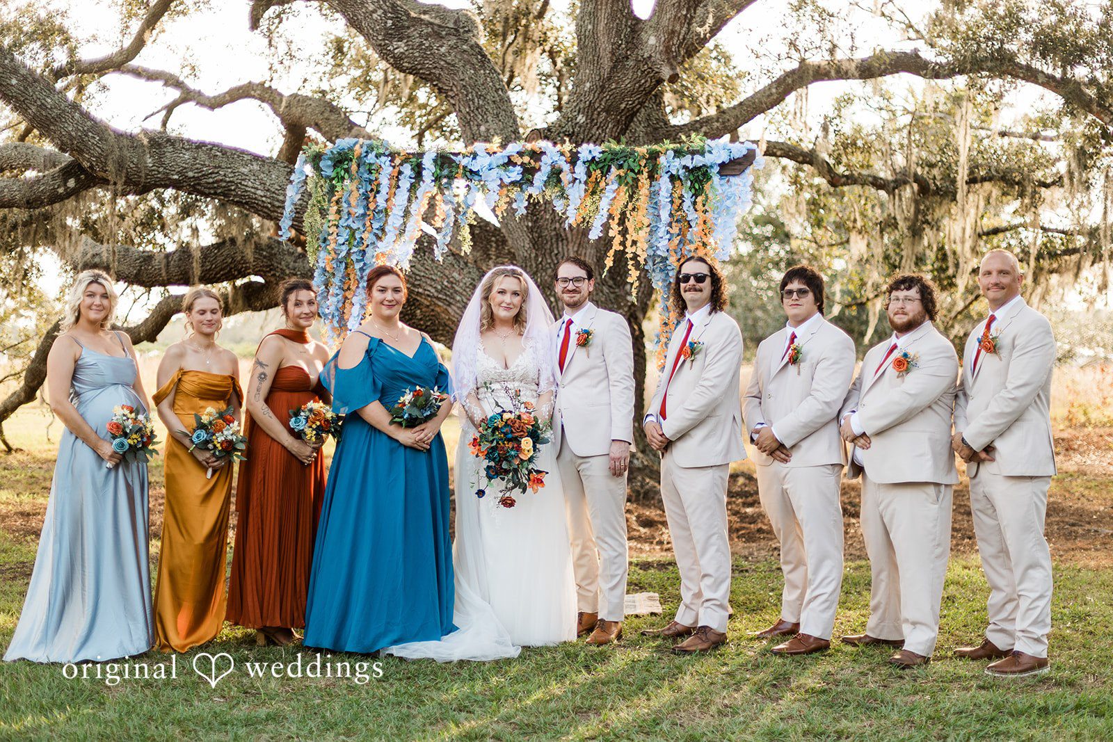 A full wedding party portrait under floral installations, styled by Tampa Wedding Photography.