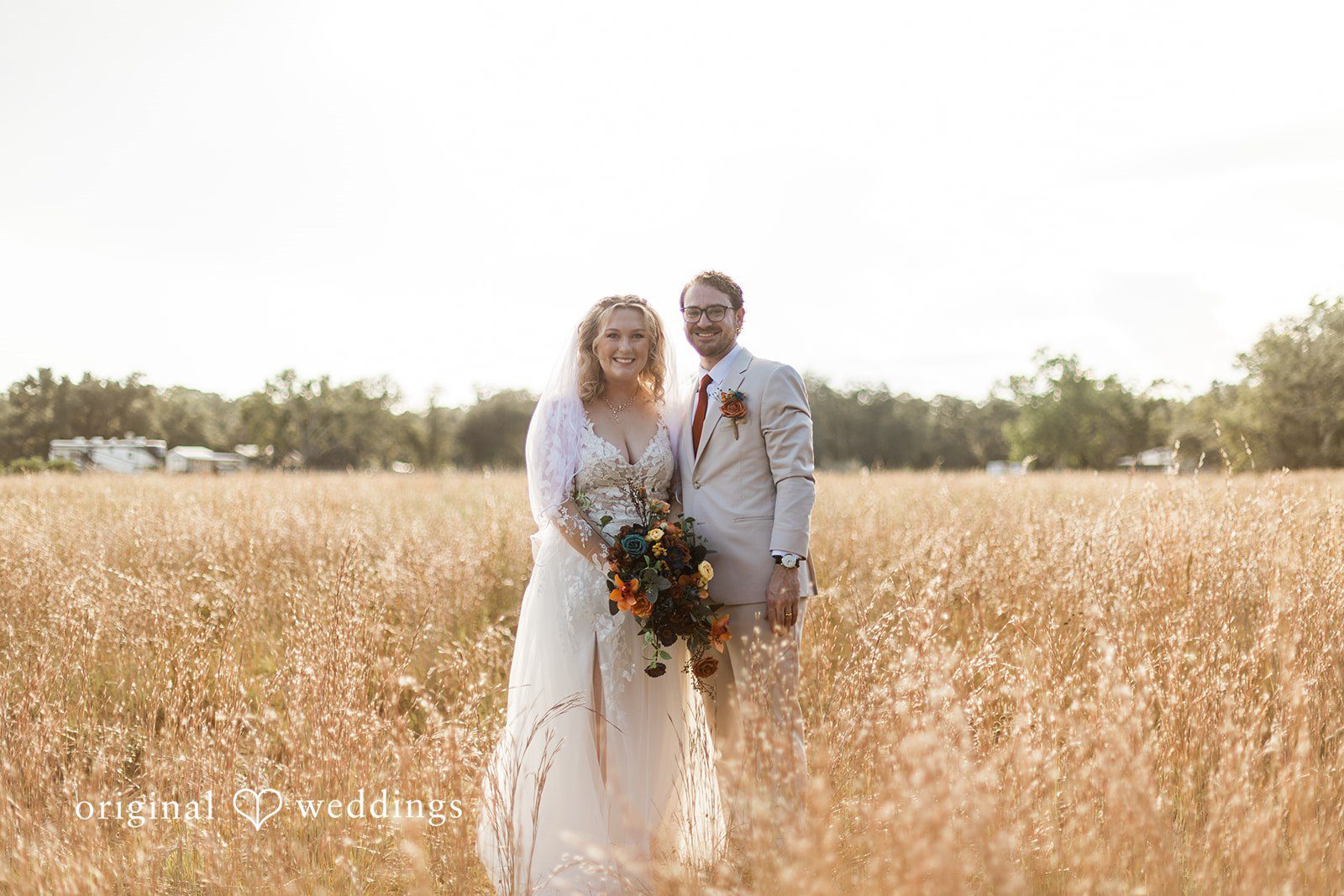 A couple standing together in tall grass, photographed in a natural Tampa Wedding Photography style.