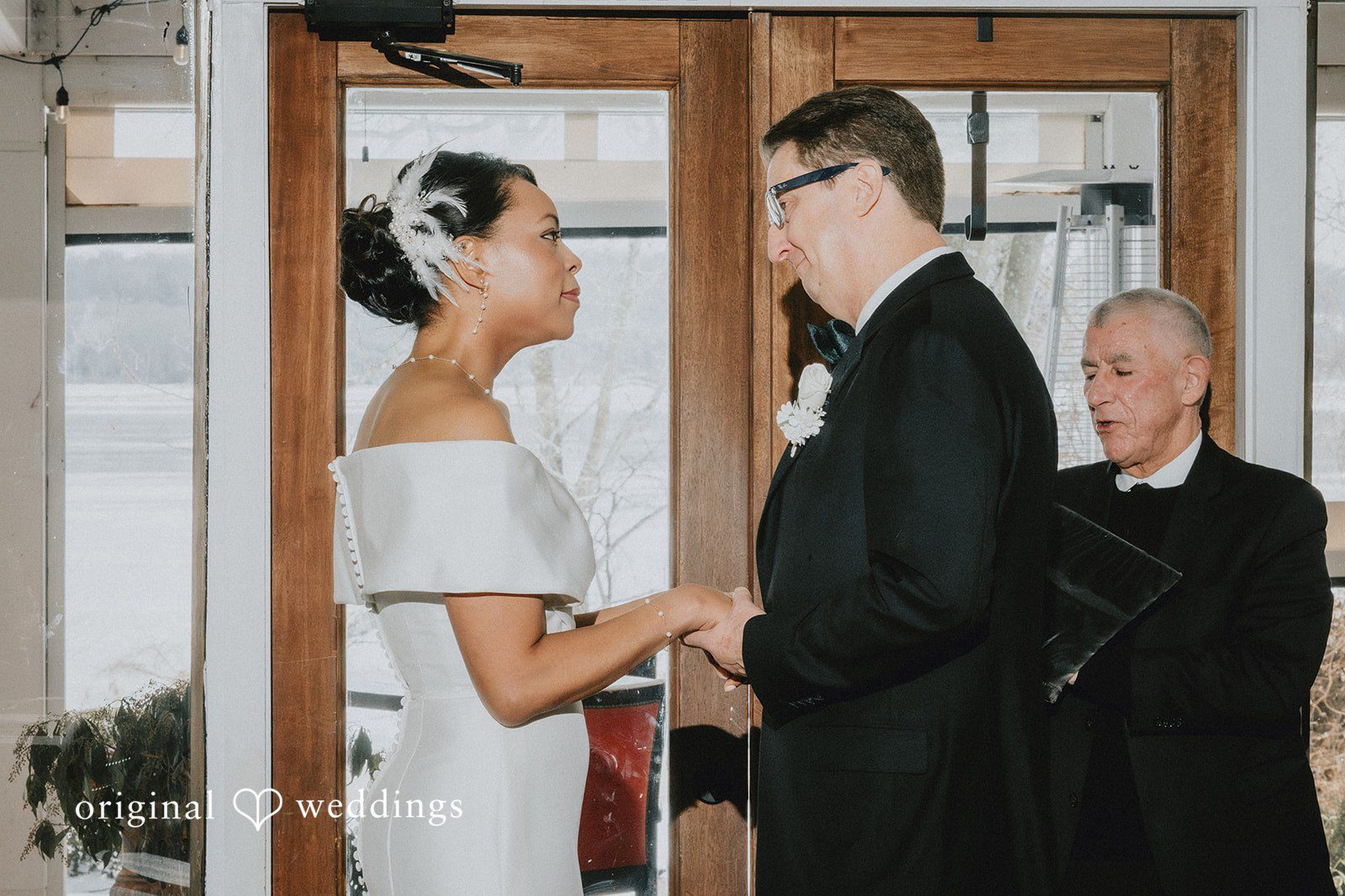 Couple standing before the priest, looking at each other at Cedar Knoll